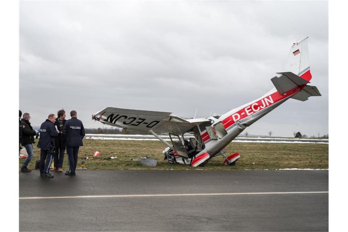 Coburg: Kleinflugzeug verunglückt - Fluglehrer stirbt Die ermittelnden Polizeibeamten stehen neben dem verunglücktem Kleinflugzeug Cessna auf dem Flugplatz in Coburg. Foto: Daniel Vogl/dpa