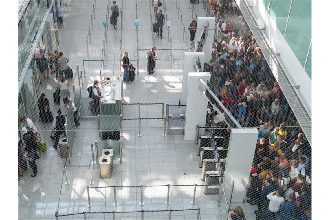 200 Annullierungen nach Terminalräumung am Münchner Airport Die ersten Fluggäste betreten nach stundenlanger Sperrung den Sicherheitscheck-Bereich. Foto: Peter Kneffel