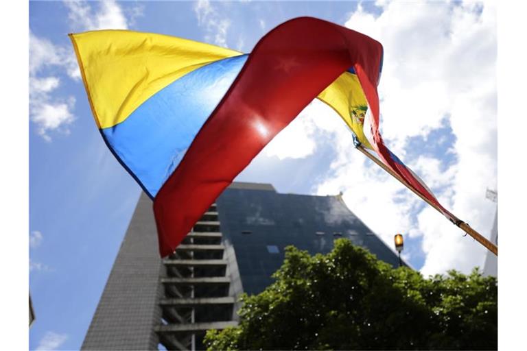 Die Fahne von Venezuela vor einem Gebäude in der Hauptstadt Caracas. Venezuelas Regierung hat den Dialog mit der Opposition nach der Auslieferung eines Vertrauten von Präsident Nicolás Maduro an die USA vorerst abgebrochen. Foto: Rafael Hernandez/dpa
