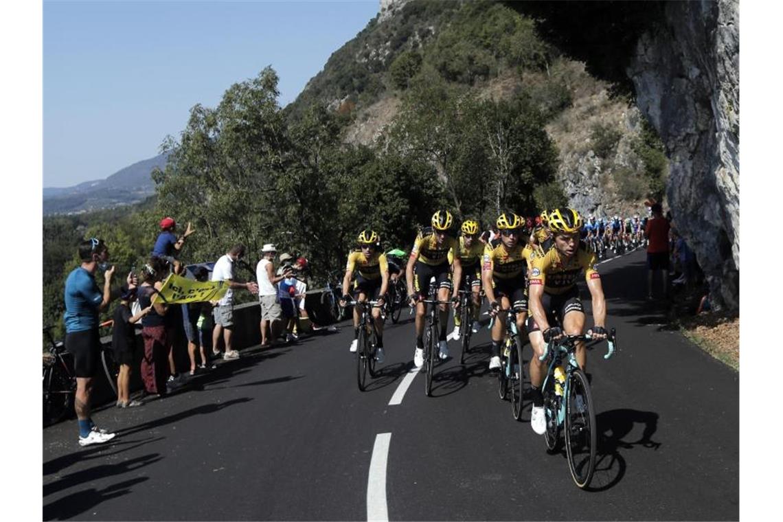 Die Fahrer vom Team Jumbo-Visma führen das Hauptfeld am Grand Colombier an. Foto: Christophe Ena/AP/dpa