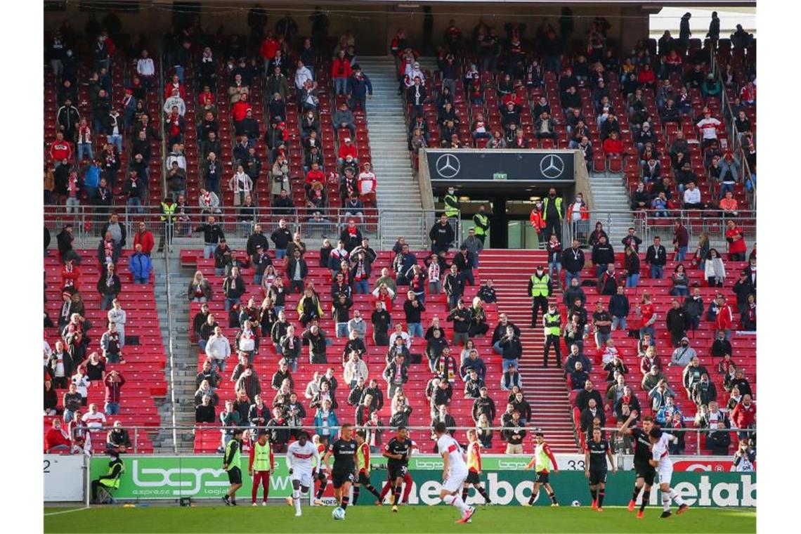 Die Fans des VfB Stuttgart sitzen mit Abstand in der Mercedes-Benz Arena. Foto: Tom Weller/dpa/Archiv