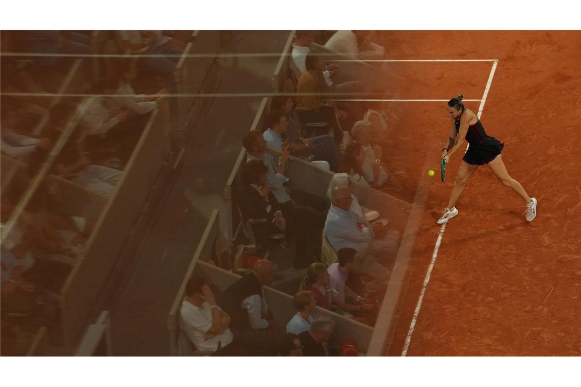 Die Fans spiegeln sich in einer Glaswand bei den French Open, während Aryna Sabalenka eine Rückhand gegen Naomi Osaka spielt.