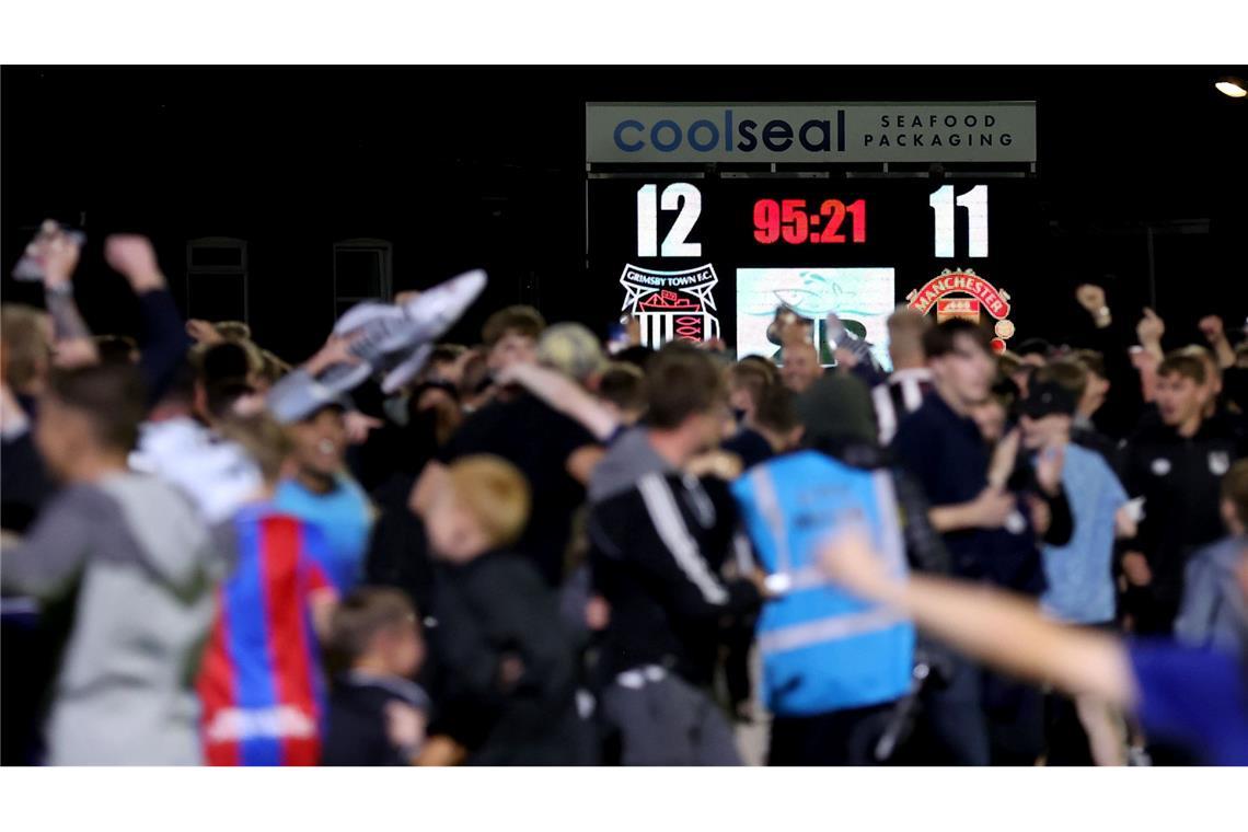 Die Fans von Grimsby Town feiern ihren Sieg im Elfmeterschießen gegen Manchester United.