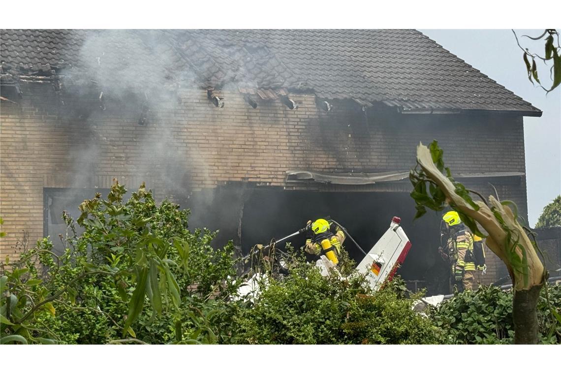 Bilder des Tages Die Feuerwehr arbeitet an der Absturzstelle, nachdem ein Flugzeug in ein Wohnhaus gestürzt ist.