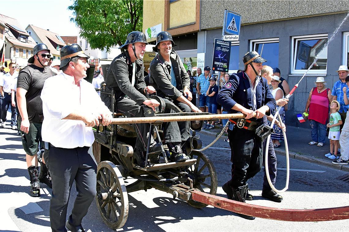 Die Feuerwehr mit einem alten Spritzenwagen lässt die Sirene aufheulen. Feier zu...