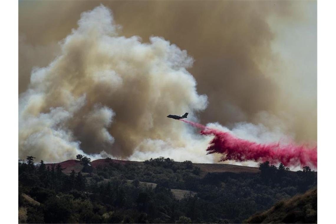 Waldbrände in Kalifornien treiben Tausende in die Flucht Die Feuerwehr setzt für Löscharbeiten der Waldbrände ein Löschflugzeug ein. Foto: Noah Berger/FR34727 AP/dpa