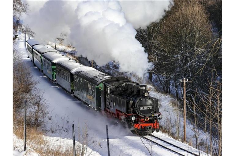 Die Fichtelbergbahn schnauft durch den Winterwald im Erzgebirge. Foto: Jan Woitas/dpa-Zentralbild/dpa