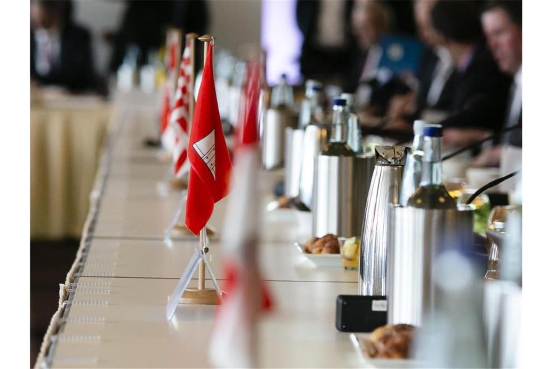 Asylbetrug, Kriminalstatistik, Terror - Innenminister tagen Die Flaggen der Bundesländer auf dem Tisch einer Innenministerkonferenz. Foto: Frank Molter/dpa/Archiv