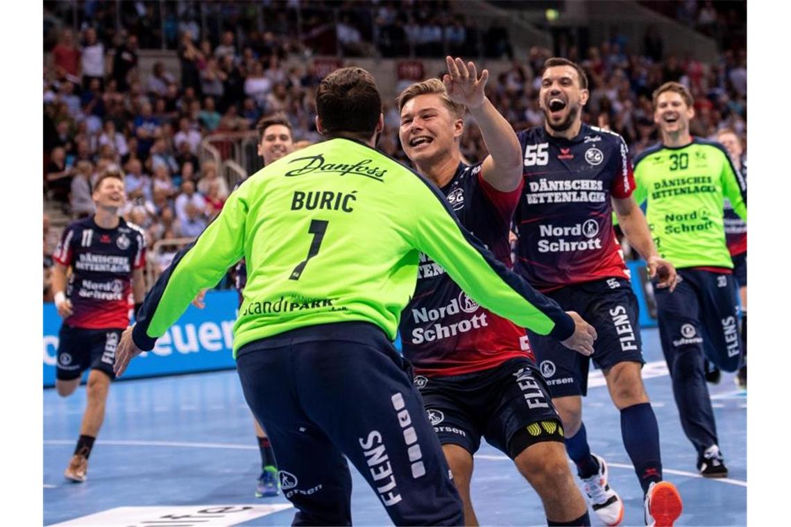 Die Flensburger Spieler jubeln nach dem Sieg im Siebenmeterwerfen. Foto: Marius Becker