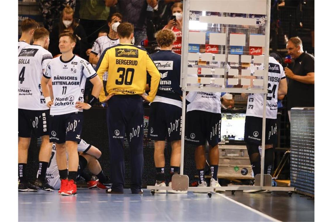 Kiel jubelt: THW-Handballer zum 22. Mal deutscher Meister Die Flensburger Spieler stehen nach ihrem Sieg vor einem Fernseher und schauen das Spiel der Kieler in Mannheim. Foto: Frank Molter/dpa
