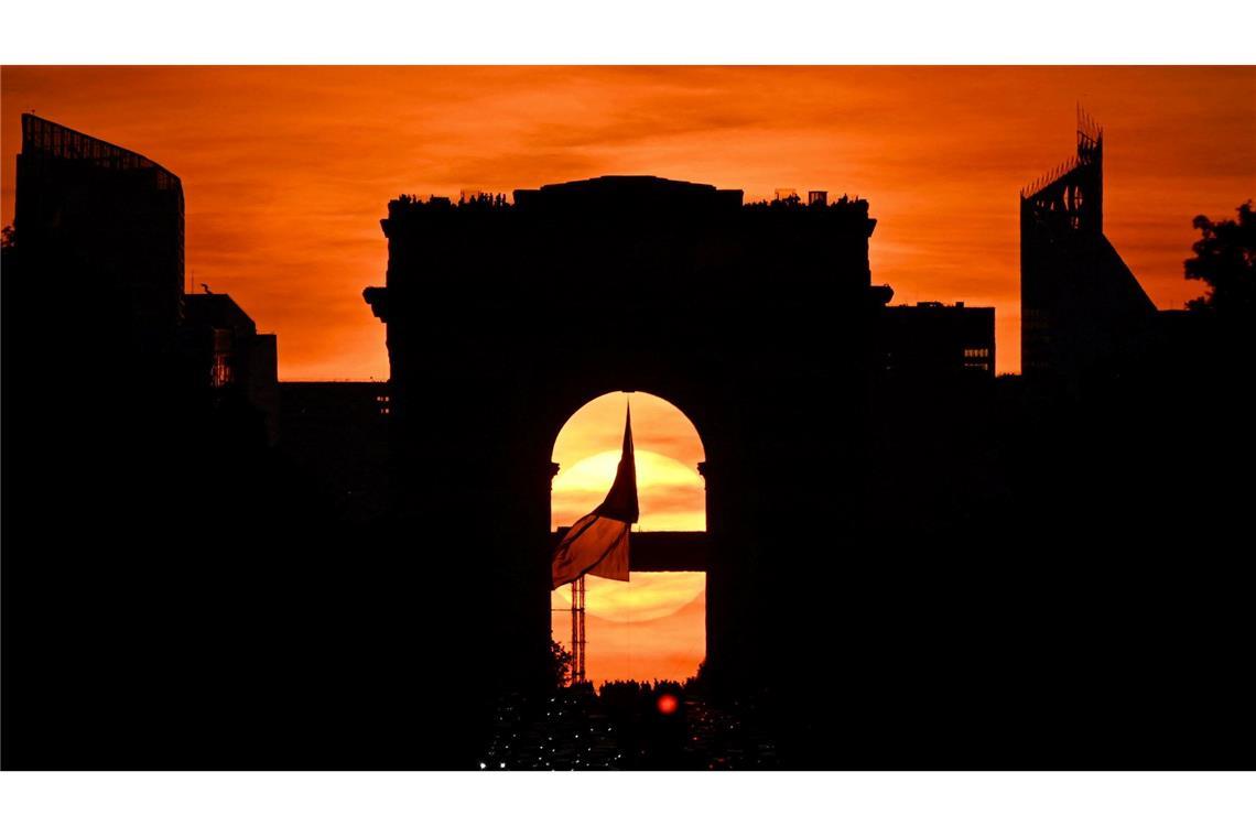 Die französische Nationalflagge weht unter dem Arc de Triomphe auf der Avenue des Champs Elysees während des sogenannten "Paris Henge"-Phänomens.