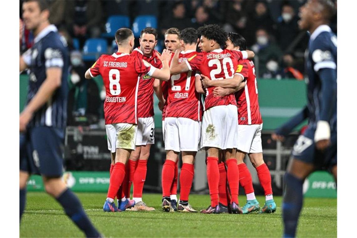 Leipzig locker, HSV und Freiburg mit Drama: Halbfinale fix Die Freiburger Spieler jubeln nach dem ersten Tor gegen den VfL Bochum. Foto: David Inderlied/dpa
