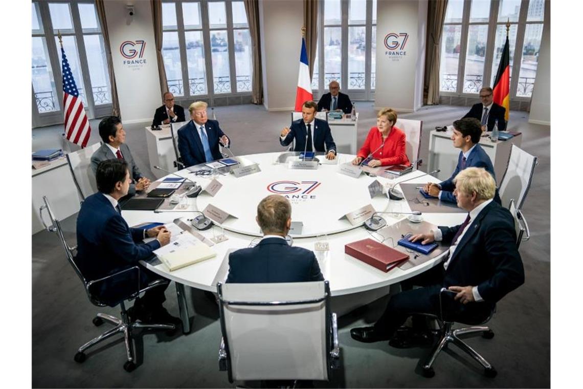 Die G7-Vertreter tagen in Biarritz: Emanuel Macron (Frankreich, M hinten), daneben im Uhrzeigersinn Bundeskanzlerin Angela Merkel, Justin Trudeau (Kanada), Boris Johnson (Großbritannien), EU-Ratspräsident Donald Tusk, Giuseppe Conte (Italien), Shinzo Abe (Japan) und Donald Trump (USA). Foto: Michael Kappeler