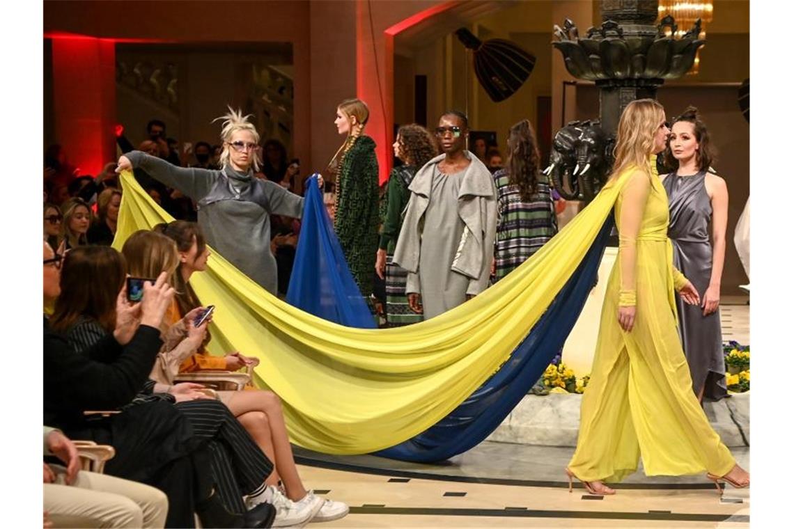 Berliner Modewoche als Zeichen für Freiheit Die geflüchtete ukrainische Tänzerin Nataliia Ovcharova trägt auf der Show von Designerin Anja Gockel eine gelb-blaue-Kreation mit einer Schleppe in den Farben der Ukraine. Foto: Jens Kalaene/dpa-Zentralbild/dpa