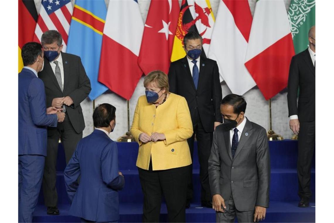 Die geschäftsführende Bundeskanzlerin Angela Merkel (CDU, M) trifft für ein Gruppenfoto zusammen mit weiteren Staats- und Regierungschefs während des G20-Gipfels in Rom. Foto: Kirsty Wigglesworth/AP/dpa