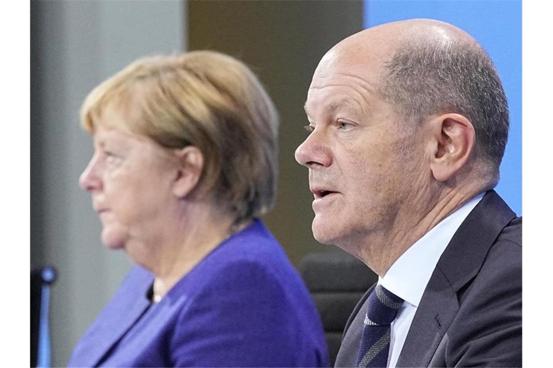 Die geschäftsführende Bundeskanzlerin Angela Merkel und ihr designierter Nachfolger Olaf Scholz bei einer Pressekonferenz im Bundeskanzleramt. Foto: Michael Kappeler/dpa POOL/dpa