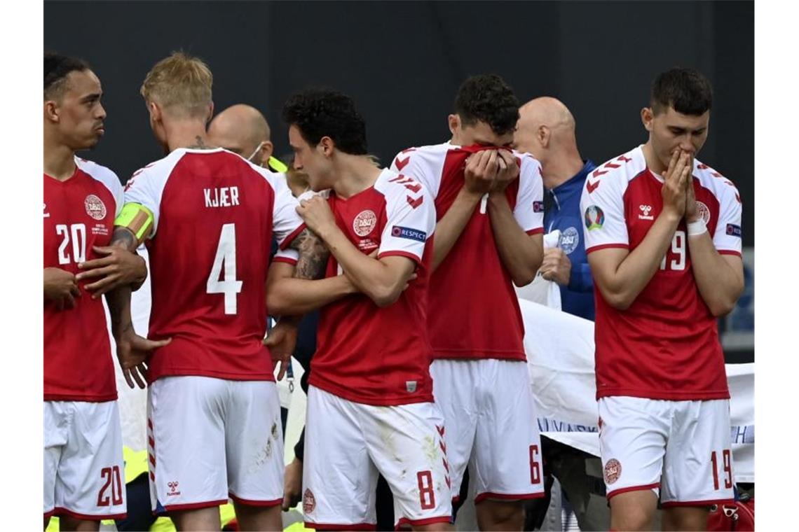 EM-Drama in Kopenhagen: Dänen-Star Eriksen kollabiert Die geschockten dänischen Spieler bildeten um den kollabierten Christian Eriksen einen Kreis. Foto: Stuart Franklin/Getty Pool/AP/dpa