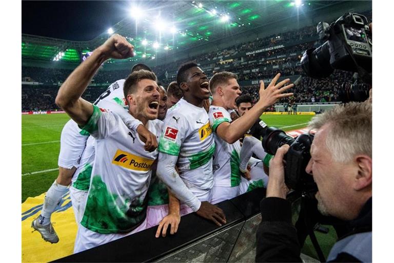 Die Gladbacher Spieler feiern den Treffer zum 2:1 gegen den FC Bayern München durch Ramy Bensebaini (r). Foto: Marius Becker/dpa