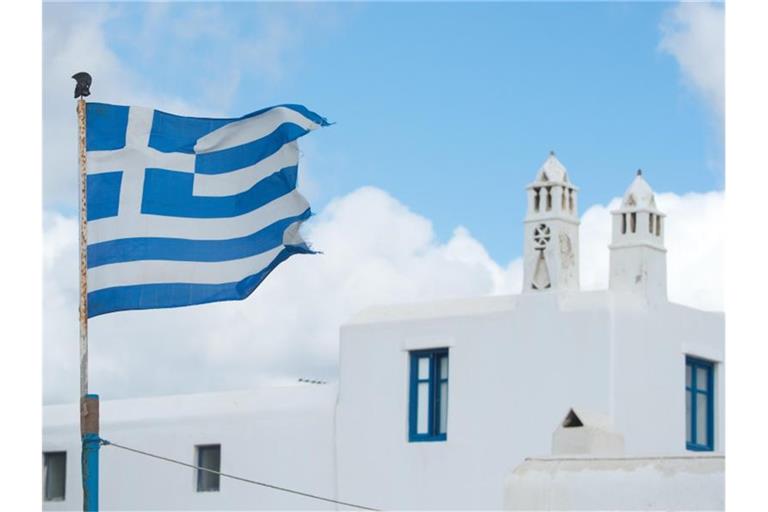 Die griechische Fahne weht auf der Insel Mykonos. Foto: Andrea Warnecke/dpa-tmn/dpa