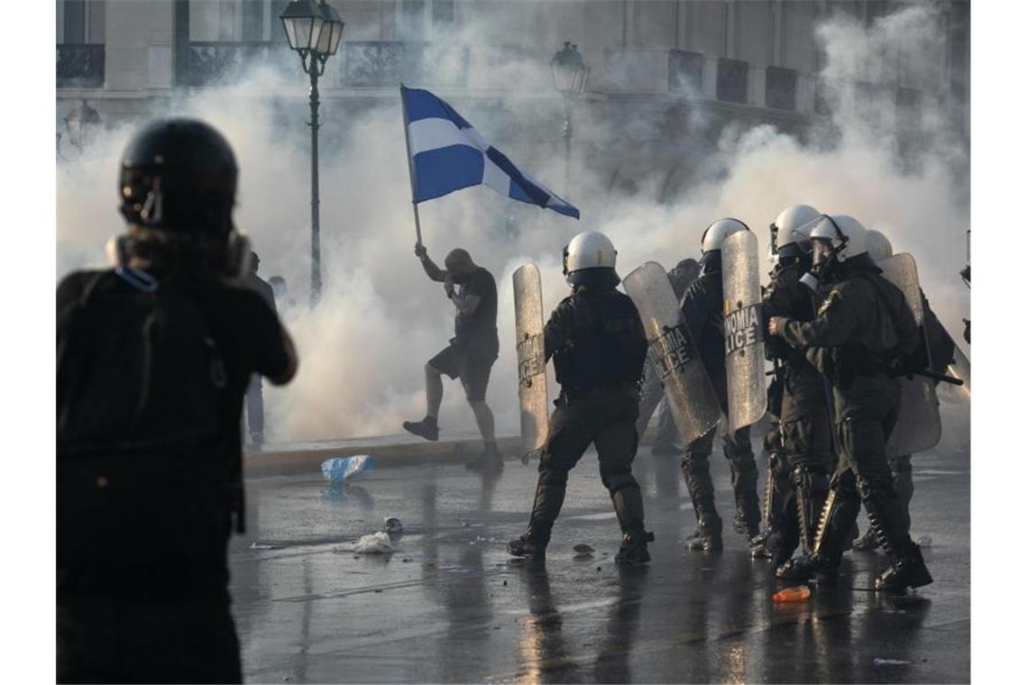 Die griechische Polizei setzt in Athen Tränengas und Wasserwerfer gegen impfkritische Demonstranten ein. Foto: Yorgos Karahalis/AP/dpa