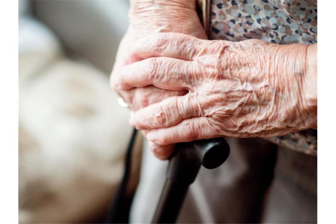Die Hände einer alten Frau auf einem Gehstock. Foto: Jana Bauch/dpa/Archivbild