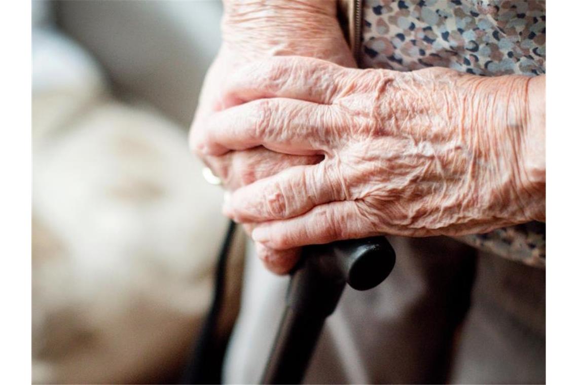 Demente Seniorin: Möglicherweise mehrere Tage lang im Wald Die Hände einer alten Frau auf einem Gehstock. Foto: Jana Bauch/dpa/Archivbild