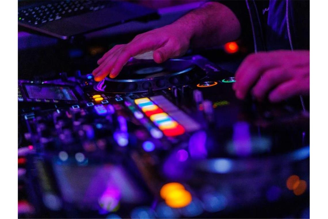 Die Hände eines DJ bedienen ein Mischpult in einem Club. (Archivbild). Foto: Philipp von Ditfurth/dpa
