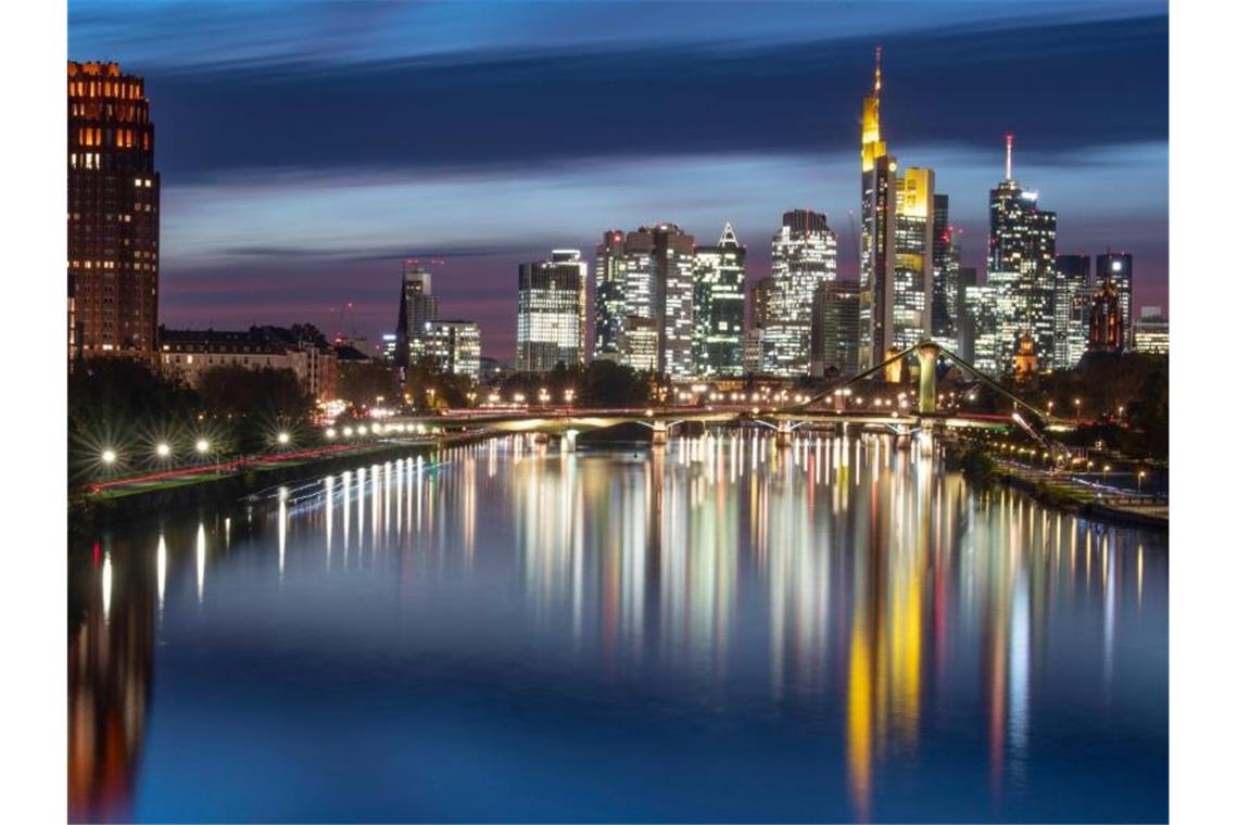 Mieten, Anbindung und Kitas - was für Familien zählt Die Hochhäuser der Bankenskyline spiegeln sich im Wasser des Main. Foto: Boris Roessler/dpa