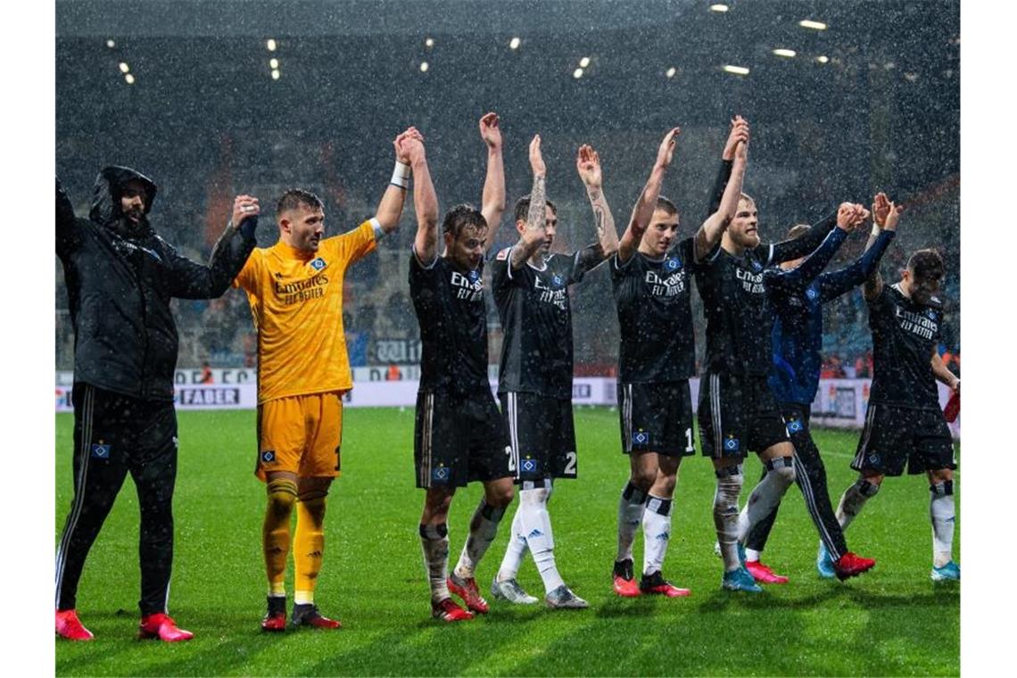 Die HSV-Spieler feiern in Bochum mit den Fans den Auswärtssieg. Foto: Guido Kirchner/dpa