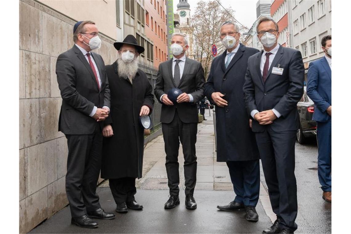 Die Innenminister stehen mit dem Polizeirabiner Shneur Trebnik vor einer Synagoge in Stuttgart. Foto: Bernd Weißbrod/dpa