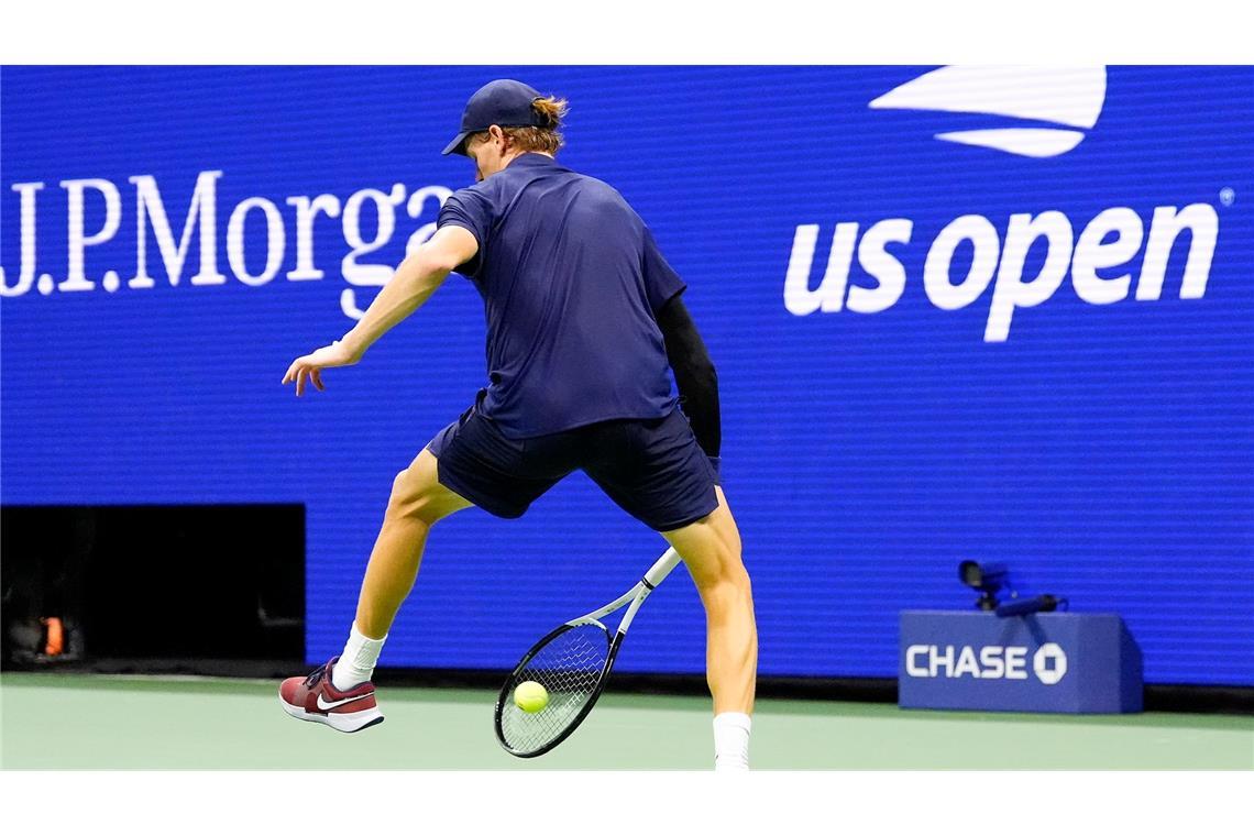 Die italienische Tennisprofi Jannik Sinner wehrt einen Schlag des Kanadiers Auger-Aliassime zwischen seinen Beinen ab.