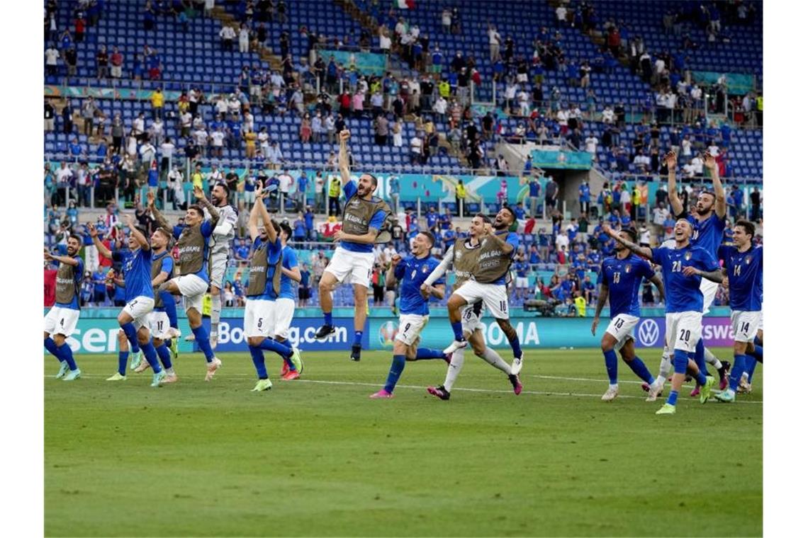 Die italienischen Spieler feiern ihren 1:0-Sieg nach dem Spiel mit den Fans auf der Tribüne. Foto: Alessandra Tarantino/AP Pool/dpa