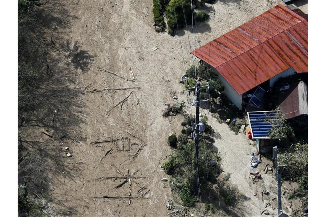 Zahl der Toten nach Taifun in Japan steigt auf 66 Die japanischen Schriftzeichen für "Wasser" und "Essen" sind neben einem Haus in den schlammmigen Boden von Marumori geschrieben. Foto: kyodo/dpa