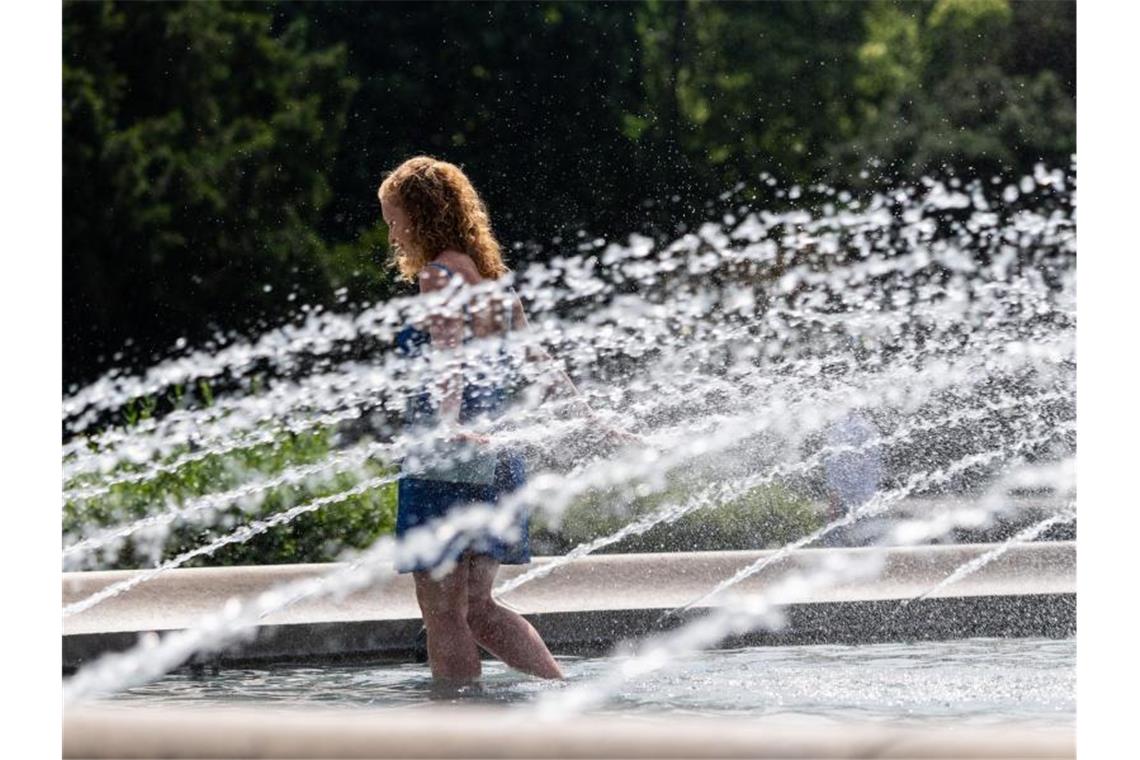 Die junge Frau aus Dresden läuft durch einen Brunnen am Albertplatz um sich abzukühlen. Foto: Robert Michael