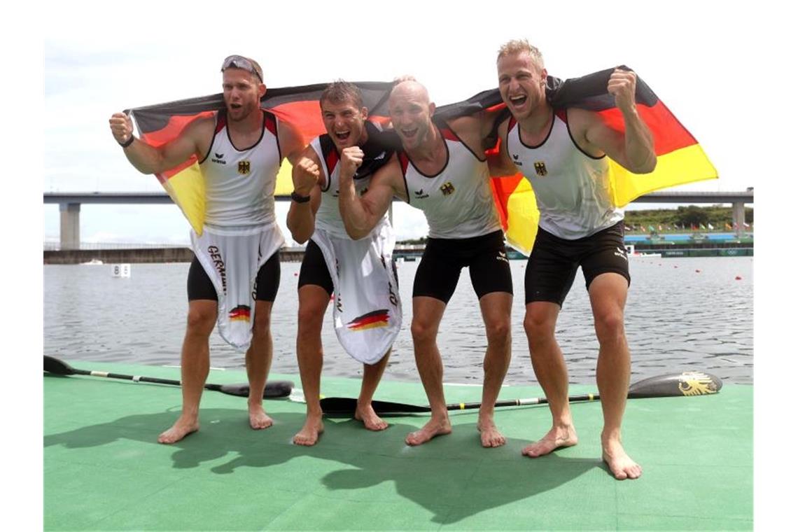 Die Kanuten des deutschen Kajak-Vierers feiern ihren Olympiasieg. Foto: Jan Woitas/dpa