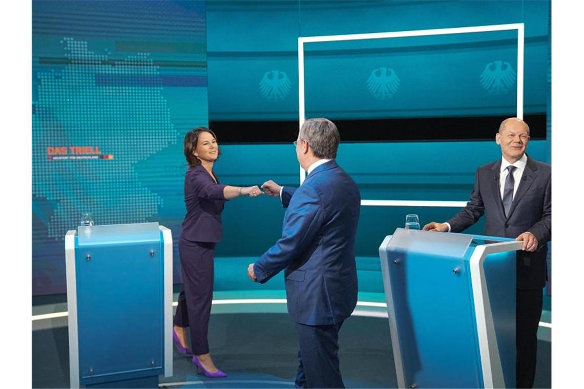 Die Kanzlerkandidaten Armin Laschet (mitte, CDU), Annalena Baerbock (l., Bündnis 90/Die Grünen) und Olaf Scholz (SPD) begrüßen sich vor der Sendung im Fernseh-Studio in Berlin-Adlershof. Foto: Michael Kappeler/dpa Pool/dpa