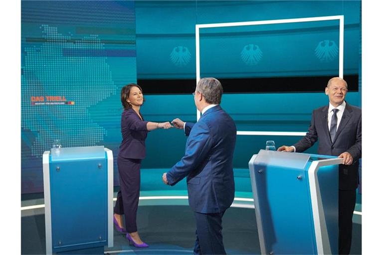 Die Kanzlerkandidaten Armin Laschet (mitte, CDU), Annalena Baerbock (l., Bündnis 90/Die Grünen) und Olaf Scholz (SPD) begrüßen sich vor der Sendung im Fernseh-Studio in Berlin-Adlershof. Foto: Michael Kappeler/dpa Pool/dpa