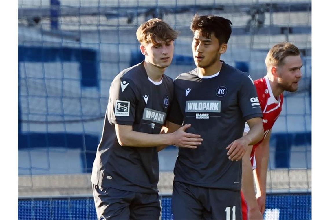 Die Karlsruher Dominik Kother (l) und Kyoung-rok Choi bejubeln einen Treffer. Foto: Uli Deck/dpa