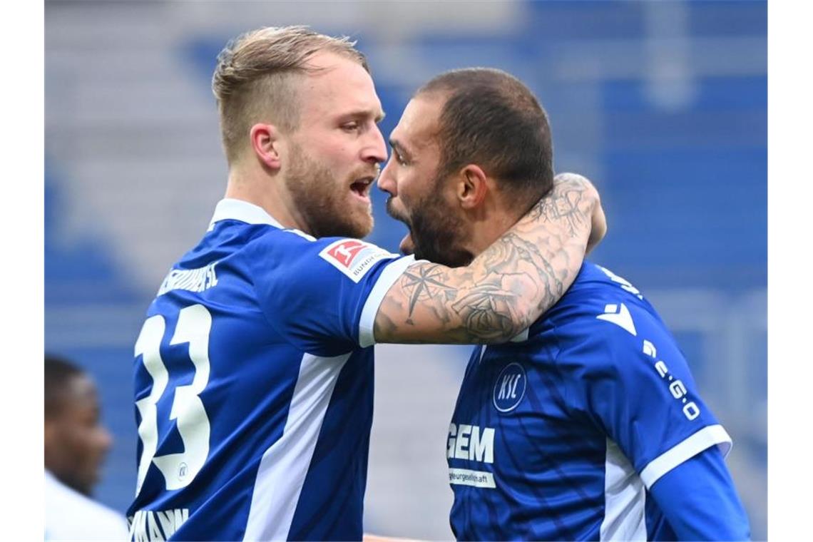 Karlsruhe trotzt belgischem Meister Unentschieden ab Die Karlsruher Philipp Hofmann (l) und Daniel Gordon bejubeln einen Treffer. Foto: Uli Deck/dpa/Archivbild