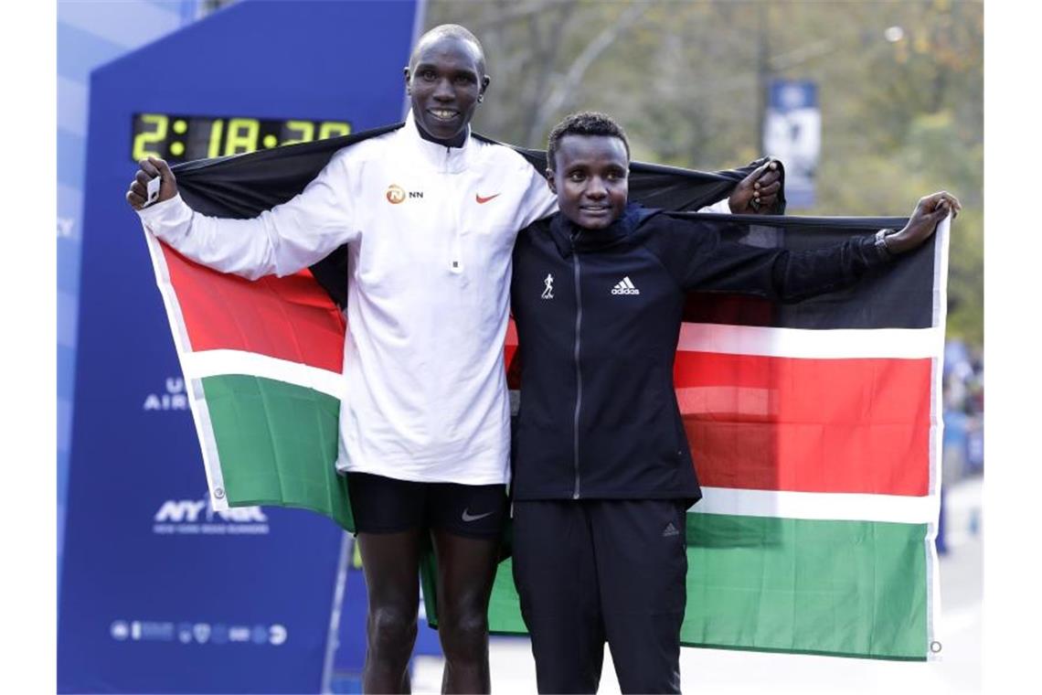 Die Kenianer Geoffrey Kamworor und Joyciline Jepkosgei posieren während der Siegerehrung mit den Landesfarben. Foto: Richard Drew/AP/dpa