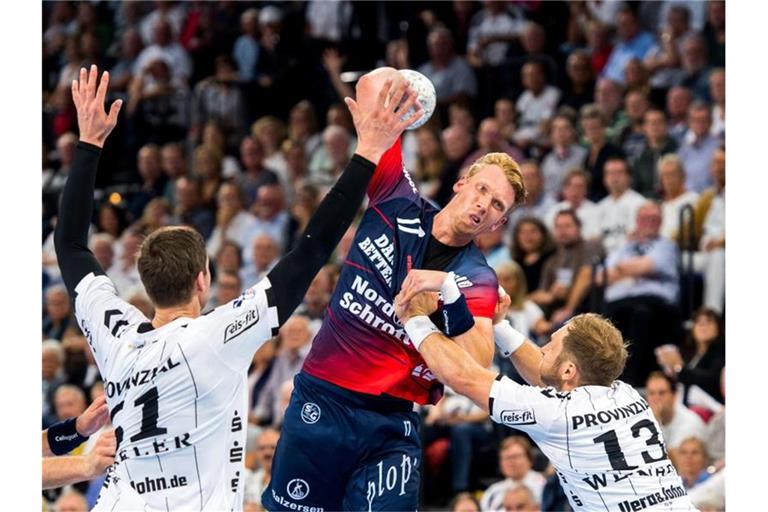 Die Kieler Hendrik Pekeler (l) und Steffen Weinhold (r) verteidigen am Wurfkreis gegen Simon Jeppsson von der SG Flensburg-Handewitt. Foto: Benjamin Nolte