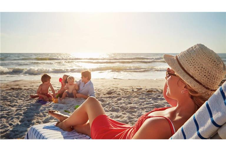 Die Kinder buddeln,  die Mutter ruht sich aus – so stellt man sich den Familienurlaub  vor. Oft geht es allerdings weniger entspannt zu.