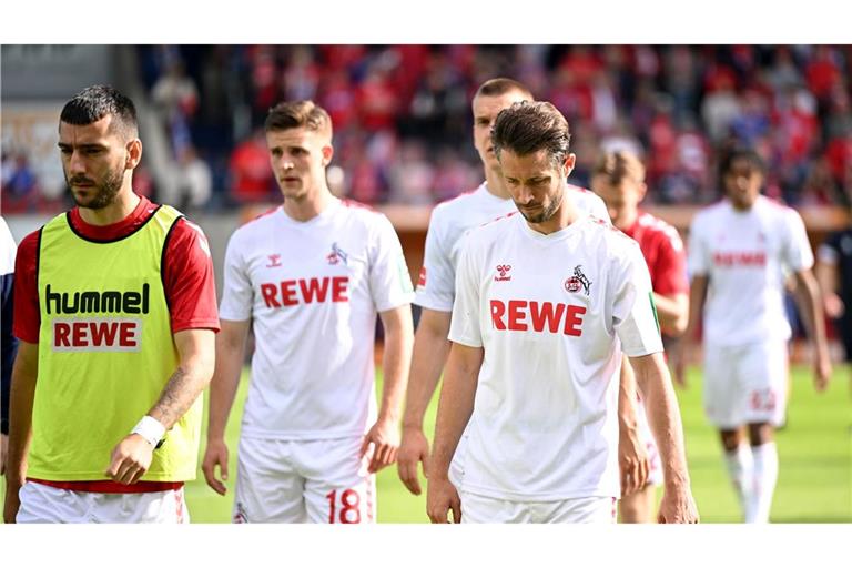 Die Kölner Spieler gehen nach der Niederlage in Heidenheim mit hängenden Köpfen vom Rasen.