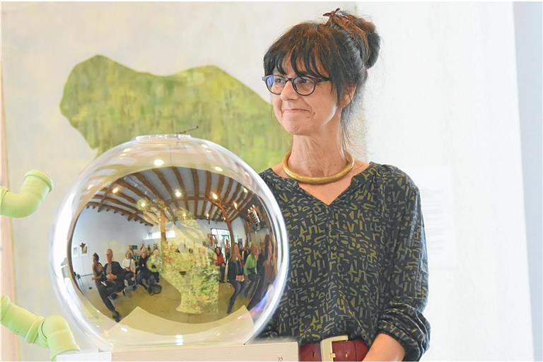 Die Künstlerin Britta M. Ischka und das Publikum, das sich in einem Kunstobjekt aus Glas spiegelt. Foto: Tobias Sellmaier