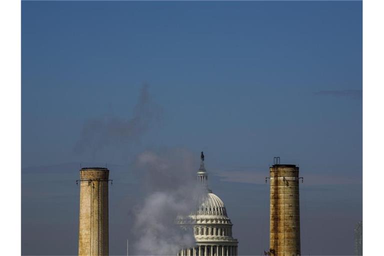 Die Kuppel des Kapitols in Washington, ist hinter den Schornsteinen des einzigen Kohlekraftwerks in der US Hauptstadt sehen. Foto: Jim Lo Scalzo/EPA/dpa