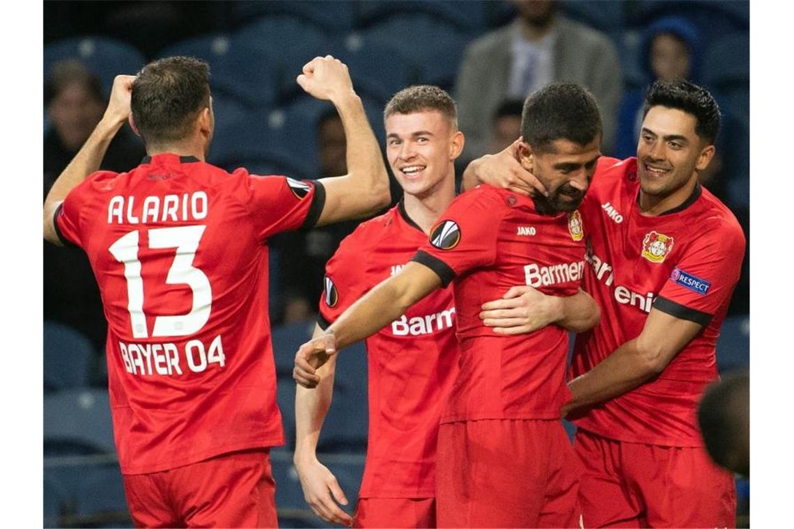 Die Leverkusener Lucas Alario (l-r), Daley Sinkgraven, Kerem Demirbay und Nadiem Amiri bejubeln das 2:0 beim FC Porto. Foto: Federico Gambarini/dpa