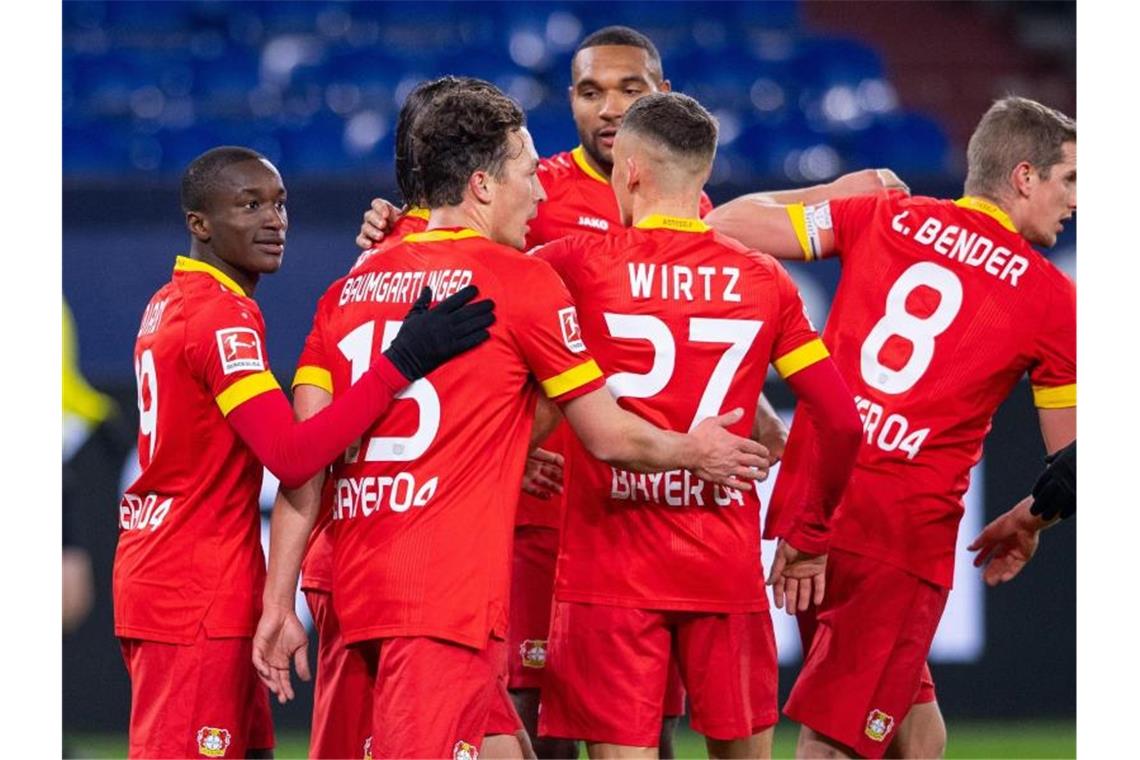 Leverkusen verlängert Schalker Misere - Trainer Baum sauer Die Leverkusener Spieler bejubeln das Tor zum 0:1 auf Schalke. Foto: Guido Kirchner/dpa