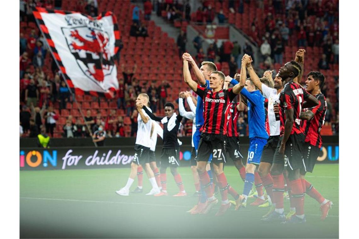 Die Leverkusener Spieler jubeln nach der Partie mit den Fans. Foto: Marius Becker/dpa