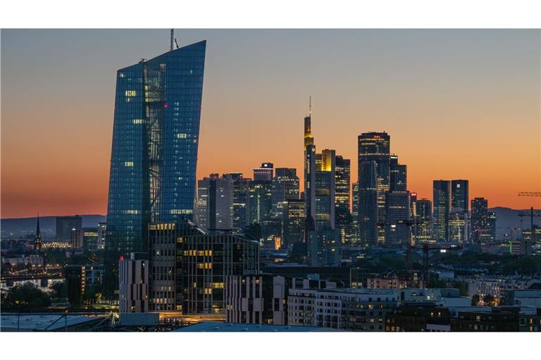 Die Lichter der Bankentürme von Frankfurt leuchten in der hereinbrechenden Dunkelheit.