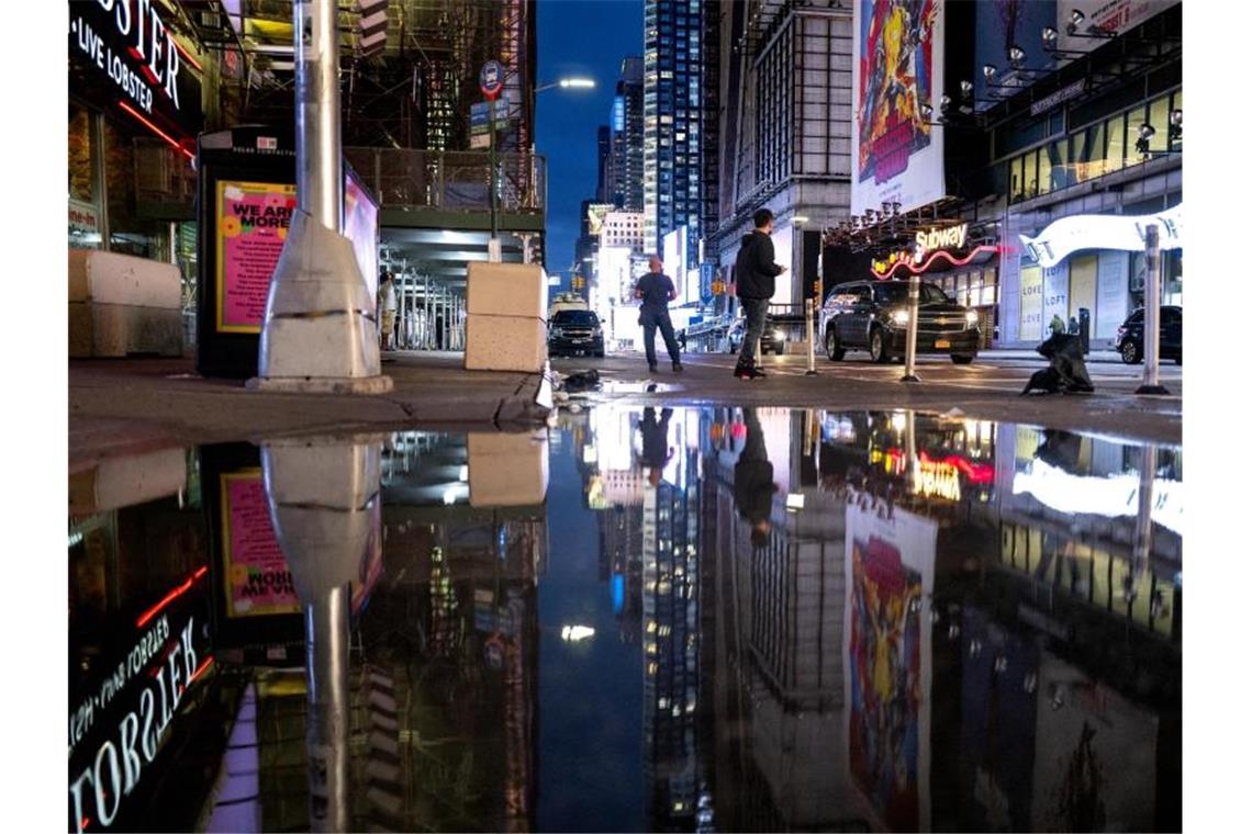 Mehrere Tote nach Extremwetter und Land unter in New York Die Lichter des Times Square spiegeln sich im Wasser. Foto: Craig Ruttle/AP/dpa